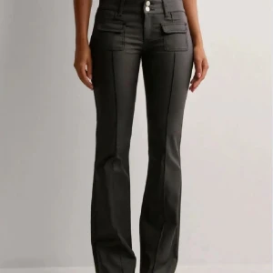 Svarta bootcut byxor med fickdetaljer - Säljer nu mina skinnbyxor från Nelly i storlek 34. Skriv för mer bilder om intresserad då dom är lite slitna längst ner vid foten. Nypris 699