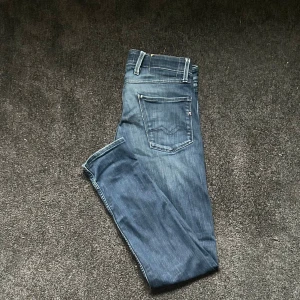 Blå Replay anbass slim jeans med slitningar - Säljer ett par blå slim jeans från Replay med snygga slitningar framtill. 