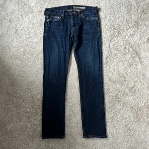 Mörkblå jeans - Mörkblå jeans med klassisk femficksdesign och raka ben. Jeansen har kontrastsömmar och en snygg läderbadge bak i midjan. Tillverkade i jeansmaterial med en stilren look som passar till det mesta. Storleken är 32/32 och har en slim passform. Skriv vid frågor eller funderingar om du inte vill köpa nu för detta sjukt billiga priset! 🙌mvh DC 🔹