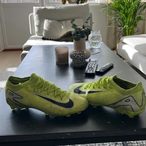Nike Mercurial fotbollsskor gul US8 - Säljer ett par Nike Mercurial fotbollsskor i en riktigt skarp gul färg med svarta detaljer och Nike-logga. Skorna har snörning, platt sula med dobbar och är tillverkade i syntetmaterial för bästa grepp på planen. Perfekta för dig som vill sticka ut på fotbollen! Lägg bud själv 