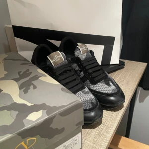 Valentino rockrunners - Snygga Valentino Garavani Rockrunner sneakers i svart och grått med camouflage-mönster. Skorna har mesh- och mockadetaljer. Storlek 42! 9/10 skick använda ett par gånger som man ser är texten på insidan lite borta men det påverkar inget❤️😤 