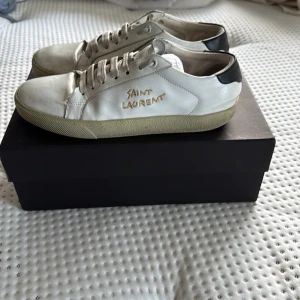 Saint Laurent vita sneakers i skinn - Använt skick som ni ser,innersulan behöver bytas ut säljer billigt pga skicket
