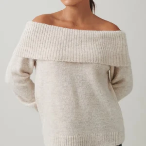 Beige offshoulder stickad tröja - Superfin beige stickad tröja med bred ribbad kant som går över axlarna för en snygg offshoulder-look. Mjuk och mysig, perfekt för kyliga dagar. Långärmad och lätt att styla med jeans eller kjol.