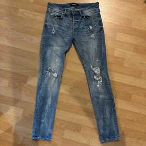 Jeans från Tigha - Säljer ett par snygga jeans från Tigha. Storlek W31 L34. De har snygga slitningar vilket ger en mer unik look på de. Modellen är 186 och väger ungefär 70kg