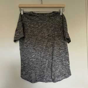 Gråmelerad t-shirt från Lindex - Gråmelerad t-shirt från Lindex i mjuk bomull. Klassisk rund hals och korta ärmar, perfekt för en avslappnad stil. T-shirten har en loose passform och är superenkel att matcha med jeans eller shorts.