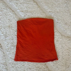 Röd tubtopp  - ⚠️ Bilden är missvisande! Toppen är mer åt det oranga hållet och inte röd!!! Storleken på toppen finns inte kvar men skulle säga att den sitter som storlek S  Jag finns tillgänglig i Skövde, Borås & Värnamo om ni vill mötas istället för att betala frakt🙈❤️🥰