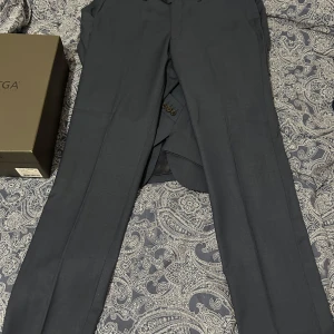 Mörkblå kostymbyxor These Glory Days - Snygga mörkblå kostymbyxor från These Glory Days i klassisk rak modell. Byxorna är tillverkade i en mix av ull och polyester med lite elastan för extra komfort. Perfekta för en stilren och dressad look.