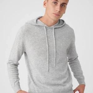 Ljusgrå stickad hoodie med huva, kashmir  - Mysig ljusgrå stickad hoodie med huva och snörning. Tröjan har lång ärm och en enkel, clean look som passar perfekt till jeans eller mjukisbyxor. Materialet är stickat och känns skönt mot huden.