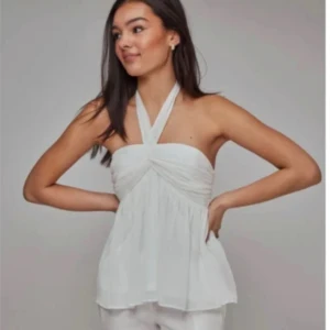 Vit topp  - Supersnygg vit  topp från nelly med knyt i nacken. Luftig och flowy passform. lite sliten så säljer för riktigt bra pris🥰