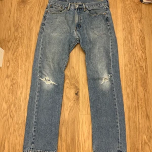 Levi's 501  perfekta slitningar - Klassiska Levi's 501 jeans i ljusblå tvätt med raka ben och slitna detaljer på knäna. Perfekt slitna, lagade mellan benen (se bild) syns inte när man använder dem. Älskar dessa jeansen men måste tyvärr göra mig av med dom (garderoben är fulllll)
