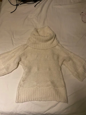 Vit polotröja från Vero Moda - Mysig vit polotröja från Vero Moda med grovstickad struktur och bred polokrage. Perfekt för kyliga dagar och enkel att styla till olika outfits.