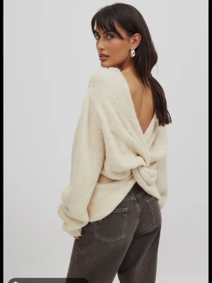 Rosa stickad tröja med knytning i rygg - Supermjuk rosa stickad tröja med lång ärm och snygg twistad detalj i ryggen som ger en öppen rygg-effekt. Tröjan har ribbade muddar och är perfekt för dig som vill ha något både mysigt och trendigt. Aldrig använd, skulle skicka tillbaka den men glömde helt bort så har inte ens haft på mig den!