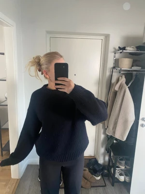 Mörkblå stickad tröja från NA-KD - Mysig mörkblå stickad tröja från NA-KD i storlek S. Tröjan har en klassisk rund halsringning, ribbade muddar och en loose fit. Perfekt för kyliga dagar och enkel att styla med jeans eller kostymbyxor.