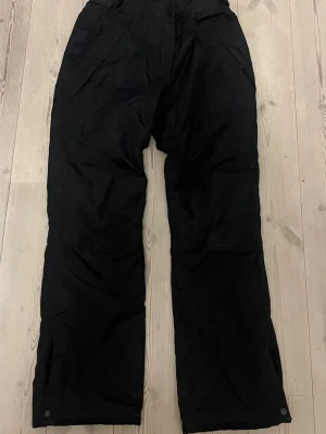 Svarta täckbyxor från Everest - Svarta skidbyxor från Everest med raka ben och hängslen.