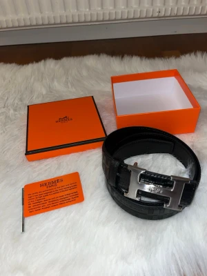 Svart Herme’s Skinn Bälte - Säljer denna svarta Skinn bälte med H spänne. Den har väldigt unika design runt om. Den är storlek 110cm