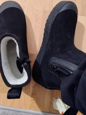 Helt nya svarta vinterboots från Tretorn 44 - Helt nya med prislapp på.Säljer ett par svarta vinterboots från Tretorn med grov sula och dragkedja på sidan. Insidan är fodrad med mjuk, vit syntetpäls för extra värme. Utsidan är i mocka och bootsen har förstärkt tåparti. Perfekta för kalla dagar !          Vattentät FSC®-certifierat naturgummi Återvunnet Handgjorda Foder i ullmix Stabil Bloom innersula Yttersula med bra grepp & ICE.Ctrl Förstärkt häl & tåhätta Lätt att ta på och av med dragkedja