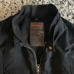 Prada jacka - Säljer denna underbara Prada jacka som passar perfekt till vintern, originellt köpt på baubau i Köpenhamn (säljer endast äkta), och är därmed 100% äkta. Se passform på sista bilden, sitter som S eller cropped M, har små defekter såsom blixtlås mm (se bilder), men ingen märkvärdigt eller så 🙂 kontakta vid bud (priset inte satt i sten)🪨!!
