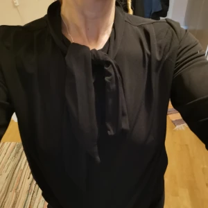 Knutblus - En svart knytblus. Fint skick och skönt material. 