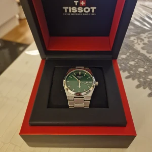 Swiss klocka - En väldigt fin klocka med silverband och grön urtavla. Klockan är helt ny och aldrig använd. Vid snabb affär kan priset eventuellt diskuteras