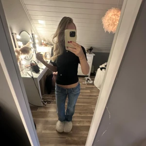 Blå lågmidjade jeans  - Säljer ett par blå jeans med låg midja. Jeansen har klassiska fickor både fram och bak, med snygga knappdetaljer på bakfickorna. Perfekt för dig som gillar en avslappnad och cool stil. Materialet är jeans och färgen är ljusblå. Jag är 168 och är ganska långa på mig. Har satt ditt två extra knappar i midjan😍