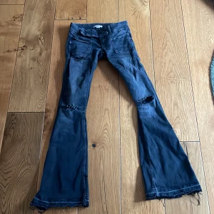 Svarta bootcut jeans med slitningar - Säljer dem populära jeansen från Gina 14+! Obs: har sprättat upp dem nere vid fötterna pga att dem var lite korta på mig som är 166. 