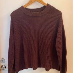 Vin röd stickad tröja från Pull&Bear - Mysig vinröd stickad tröja från Pull&Bear i storlek S. Tröjan har ribbad struktur, rund halsringning och långa ärmar. Perfekt för att hålla sig varm under kyliga dagar och har en loose passform som ger en chill vibe. Lite nopprig