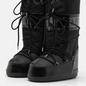 Svarta Moon Boots black on black - Säljer ett par svarta höga Moon Boots i stl 38-40 som är obetydligt använda då jag fick dessa i present men önskade mig låga. Ordinarie pris ca 2400kr.