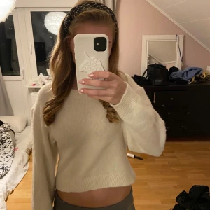 Vit croppad stickad tröja Divided - Säljer en vit croppad stickad tröja från Divided. Tröjan har lång ärm, rund hals och är gjord i mjukt material som känns skönt mot huden. ❣️