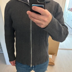 Kofta med dragkedja - Säljer en  snygg mörkgrå kofta med  dragkedja . Storlek L 
