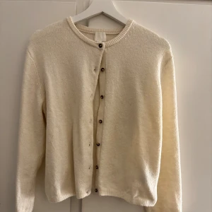  kofta från H&M  - Supermjuk krämvit kofta från H&M i storlek XS. Jag skulle säga att den här koftan passar en xs-m beroende på hur man vill att den ska sitta💘 Koftan har rund halsringning, långa ärmar och knäpps med bruna knappar framtill. Väldigt enkel att styla till olika outfits.
