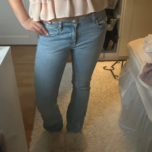 Ljusblå bootcut jeans  - Snygga ljusblå jeans från Levi's med klassisk femficksdesign och bootcut-ben. Jeansen har låg midja och är tillverkade i mjukt denimtyg som sitter skönt. Perfekt för dig som gillar en avslappnad och trendig look.