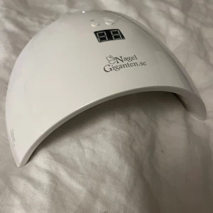UV LED Nagellampa - UV LED nagellampa från NagelGiganten med digital display och timerfunktion (30/60 sekunder). Inkluderar strömadapter. Lampan är i gott skick utan synliga defekter eller slitage. Ursprungspris 500kr