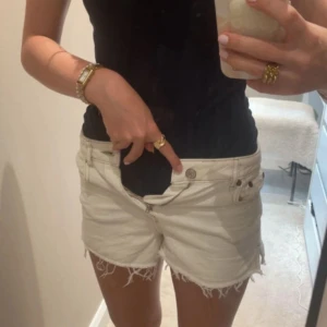 Vita jeansshorts med fransig kant - Säljer ett par vita jeansshorts med fransig rå kant och klassisk femficksmodell. Shortsen har normal passform, bälteshällor och dragkedja med knapp framtill. Perfekta för varma dagar och en chill look. Shortsen är i stoleken 152 och är från Zara. Skriv såklart till mig ifall du har några frågor eller funderingar!!💕
