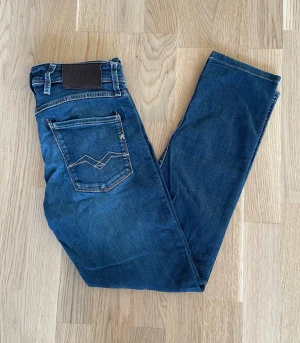 Mörkblå Replay Anbass W30 - Jag säljer dom här riktigt snygga Replay Anbass jeansen som är i storlek W30. De är upplagda så utgå ifrån måtten. Dom är i fint skick utan skador. Tveka inte att höra av er!                                          Mått: Längd=94cm. Midja=38cm