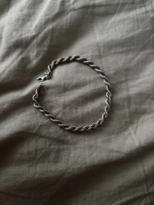 Flätat armband i äkta silver 925 och är 4 mm - Snyggt armband i äkta silver 925 med tvinnad, flätad design. Klassisk och stilren look som passar perfekt till din vardagsstil. Lås med karbinhake för extra säkerhet. Perfekt accessoar för dig som gillar minimalistiska smycken.