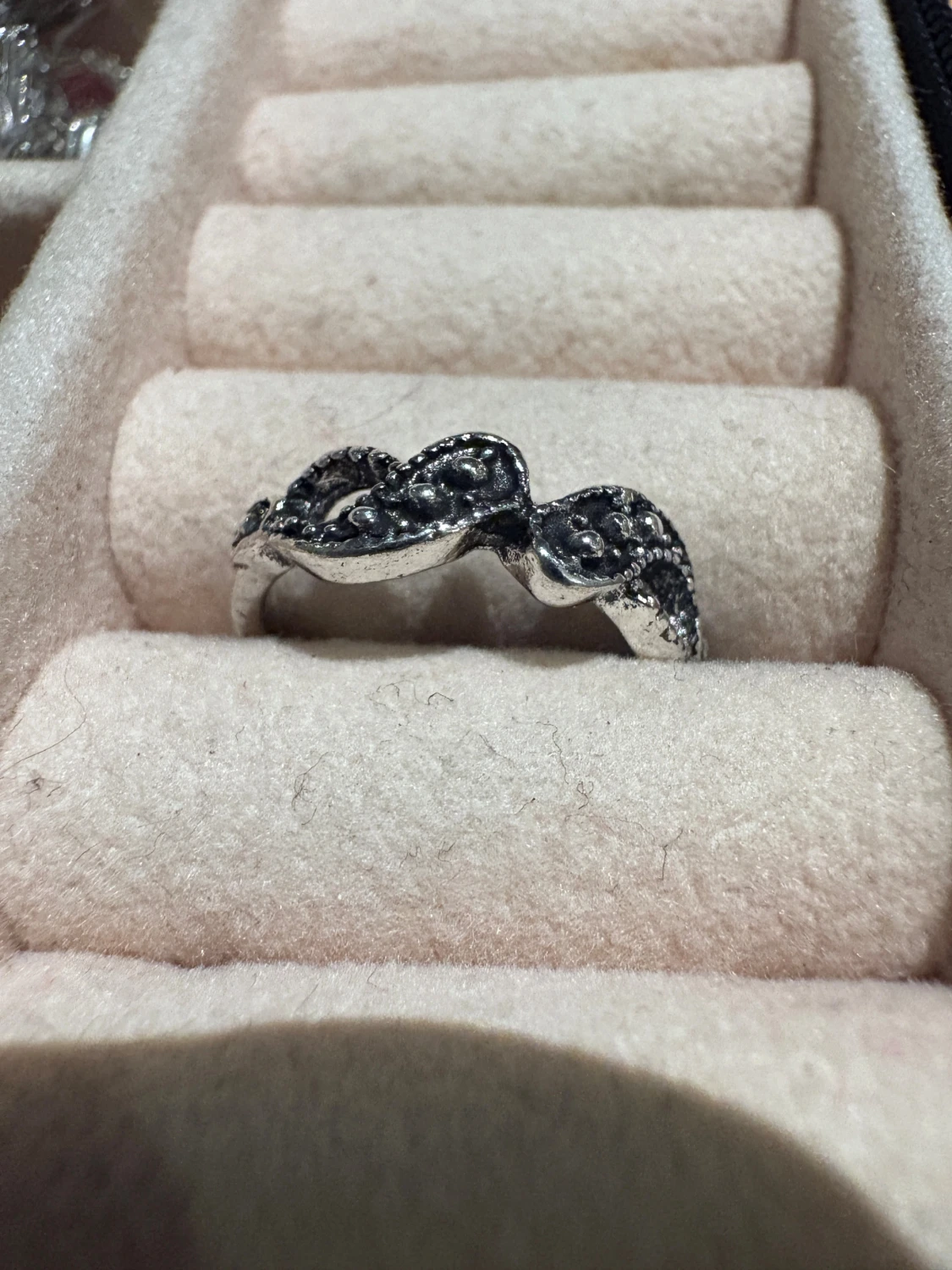 Silverfärgad ring med vågig design