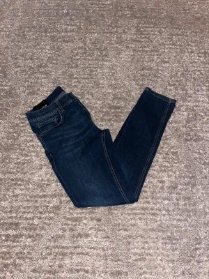 Dondup George  - Hej jag säljer ett par Dondup George i nyaste modellen. Jeansen i riktigt snygg marinblå färg perfekt för dig som vill ha ett par kvalitetsjeans med grym passform. Nypris ≈4000kr, mitt pris 899kr.  Skick: 9/10 Storlek: W34 Midja: 42cm Lår: 24cm Ytterlängd: 100cm Innerlängd: 80cm  Skriv gärna om du vill ha fler bilder eller har frågor!