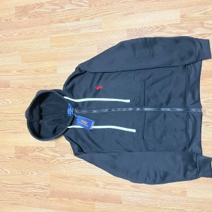 Svart hoodie Polo Ralph Lauren L/M - Svart Polo Ralph Lauren i helt ny skick med tagen på också och i storlek L, men passar även i storlek M.   INTE ÄKTA 