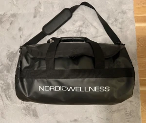 Tränings väska  - Säljer en helt ny EXKLUSIV Nordic Wellness gym väska som inte går att köpa. Den har ALDRIG använts utan kom i plast och ingen etikett. Det finns inga defekter på den och jag säljer den så redan har en väska så denna kommer inte till användning. Om du letar efter en bra och smidig väska som du kan ta med till träningen så är denna det perfekta valet för dig!