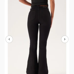 Svarta bootcut jeans  - Snygga svarta jeans med bootcut passform.. Byxorna har klassiska fem fickor, bälteshällor och knappstängning fram. Materialet är stretchigt och sitter tajt över höften innan de blir vidare nedtill. Perfekta för dig som gillar en trendig siluett. Helt nya med lapparns kvar. Inte använda alls. Betalade 599 för de men nu säljs de på hemsidan för 399. + frakten då.