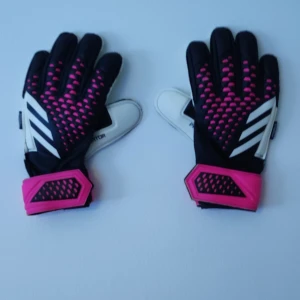 Adidas målvaktshandskar svart/rosa - Säljer ett par Adidas målvaktshandskar i svart, vitt och rosa med coola prickdetaljer och de klassiska tre ränderna på ovansidan. Handflatan är vit och mudden är rosa med svart Adidas-logga. Perfekta för fotbollsmatcher och träning.