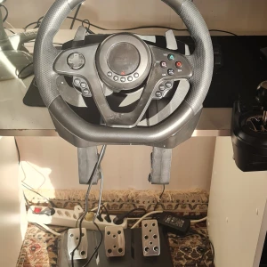  Driving Force Racing Wheel & Pedals -  racerratt med pedaler och växelspak. Perfekt för realistisk racingupplevelse på PC och konsol. Ratten har många knappar, 900° rotation och slitstarka metallpedaler. Växelspak med 6 växlar. Mycket fint skick, inga synliga defekter.