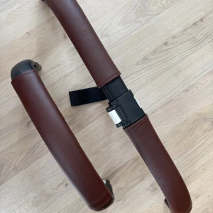 Nysydda handtagsskydd donkey 3/5 - Nysydda skydd till handtag samt en bygel. Dessa passar till Bugaboo Donkey 3 och 5. Dessa träs på över original handtag o byglar, för att dölja/skydda. För att få på dessa behöver man lossa handtaget, om du behöver hjälp med det är det bara skriva, det är superenkelt. Därefter sitter dessa ordentligt på plats utan att skava eller åka av. Brun läderimitation.