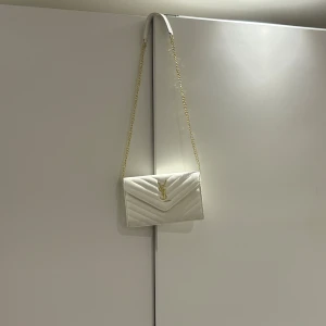 Vit YSL-väska 🤍 - Intressekoll på min vita YSL-väska 🤍 Såå fin och passar verkligen till allt – både vardags och fest! Har bara använt den ett fåtal gånger så den är i superbra skick. Klassisk modell med den ikoniska YSL-loggan framtill ✨  Kikar bara lite om det finns intresse innan jag bestämmer mig 💭 Kom gärna med prisförslag om du är intresserad 💌