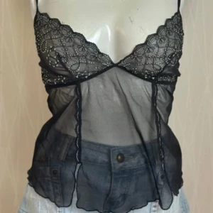 Svart topp med spetsdetaljer - Svart topp med spetsdetaljer passar storlek xs-m