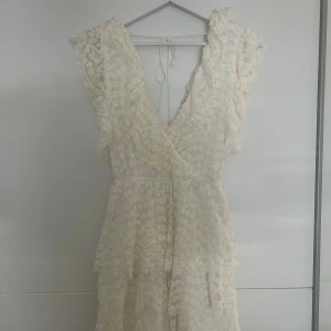 Vit spetsklänning - Säljer min studentklänning! Endast använd några timmar under studenten. Är i bra skick syns inte att den använts. Köpt från Nelly