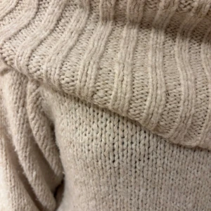 Beige stickad polotröja Gina Tricot - Supermysig beige stickad polotröja från Gina Tricot. Tröjan har en bred, ribbad polokrage och långa ärmar med ribbade muddar. Perfekt för kalla dagar och enkel att styla till jeans eller kjol.