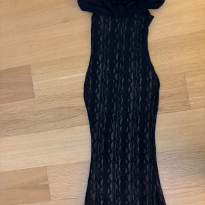 Svart offshoulder långklänning i spets - Svart långklänning med offshoulder. Den passar perfekt i längd för mig som är 167.  Säljer för att jag valde en annan, endast testad! 