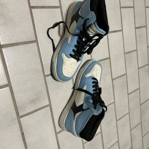 Highs blå och vita skor - Snygga skor i ljusblått, vitt och svart. Skorna har klassisk hög siluett, svart snörning och perforerade detaljer på tån. Perfekta för dig som vill sticka ut med en ikonisk sneakerstil.