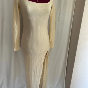 Ribbad stretchig långklänning från SHEIN - Lång ribbad klänning i ljusgult från SHEIN. Klänningen har lång ärm, rundad halsringning och en snygg slits framtill. Tillverkad i polyester med ett innerfoder som gör klänningen mindre genomskinlig SÅ snygg på.